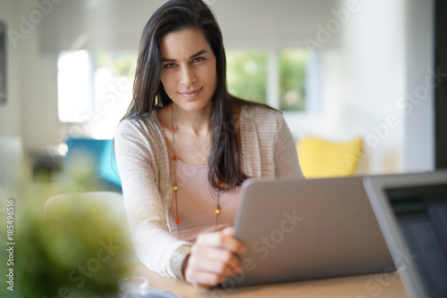 Portrait of brunette girl working on laptop computer