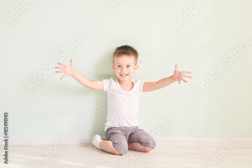 Happy cute child reaching out his palms and catching something.