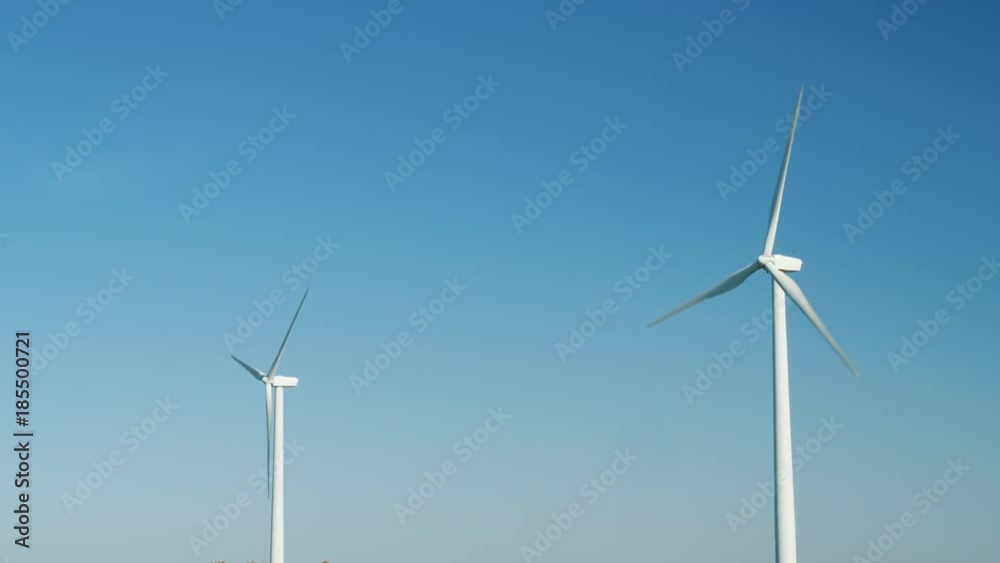 Two wind generators against the blue sky. Alternative energy sources Two wind generators against the blue sky. Alternative energy sources