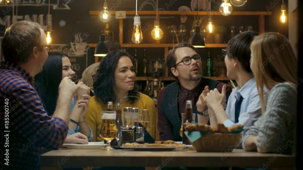 Diverse Group of Young People Have Fun in Bar, Talking, Telling Stories and Jokes