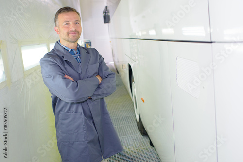 Portrait of mechanic beside bus photo