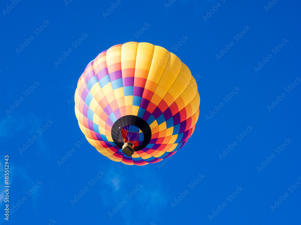 Fototapeta premium Colorful hot air balloon flying in the bright blue sky during Winthrop Balloon Festival in Washington state