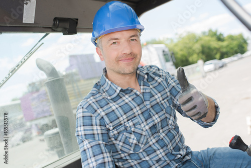 Man in forklift holding his thumb up