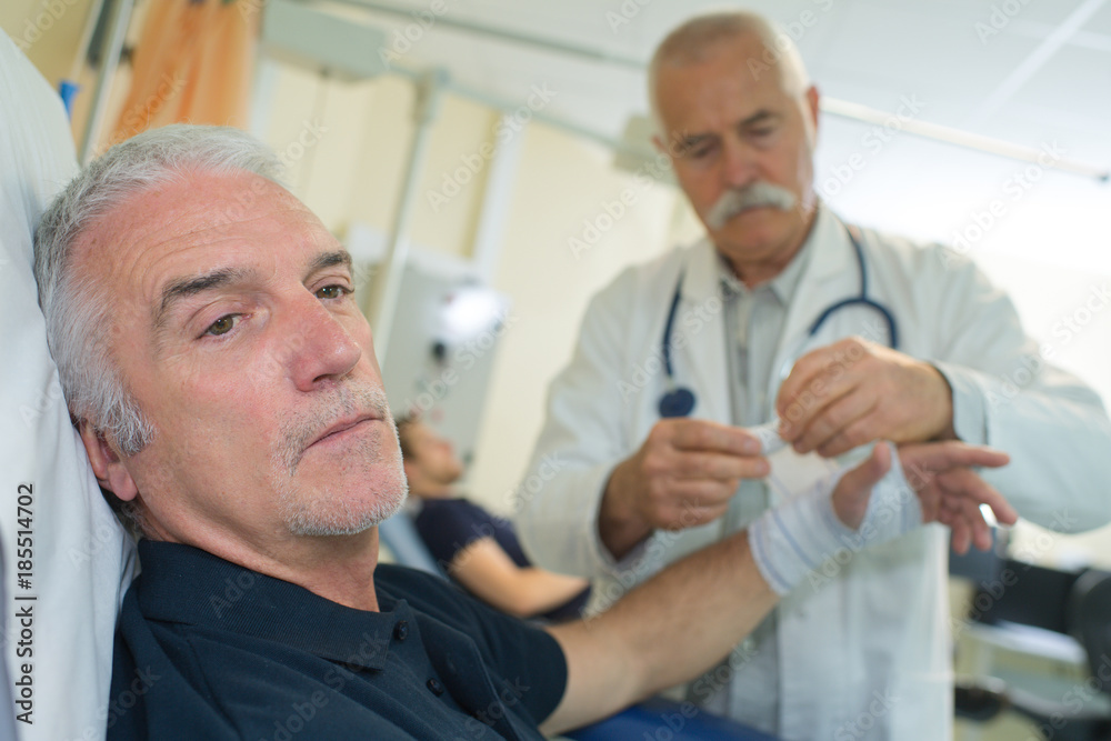 Fototapeta premium senior doctor giving bandaging patient