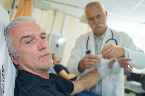 senior doctor giving bandaging patient