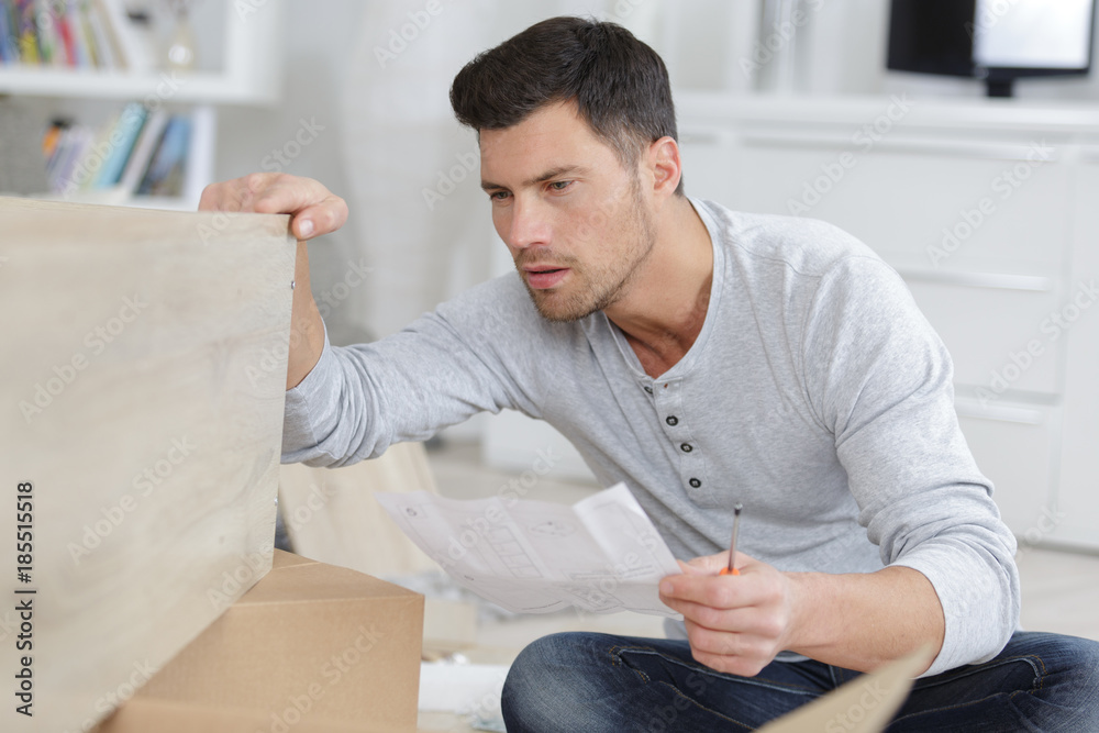 man assembling shelf at home man assembling shelf at home