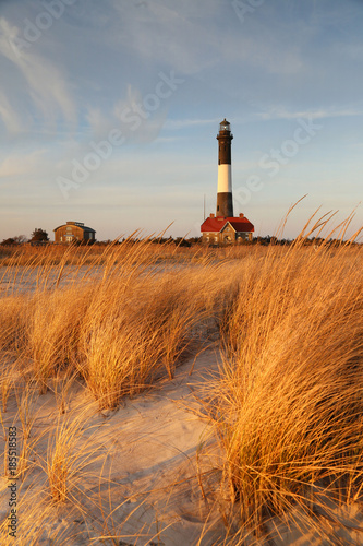 Scenic Fire Island Lighthouse with beach, dunes, dune grasses in late afternoon light.