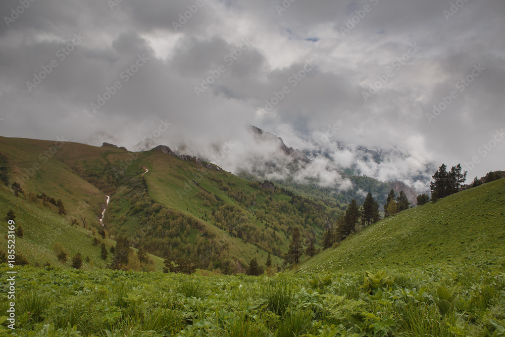The formation and movement of clouds over the summer slopes of Adygea Bolshoy Thach and the Caucasus Mountains The formation and movement of clouds over the summer slopes of Adygea Bolshoy Thach and the Caucasus Mountains