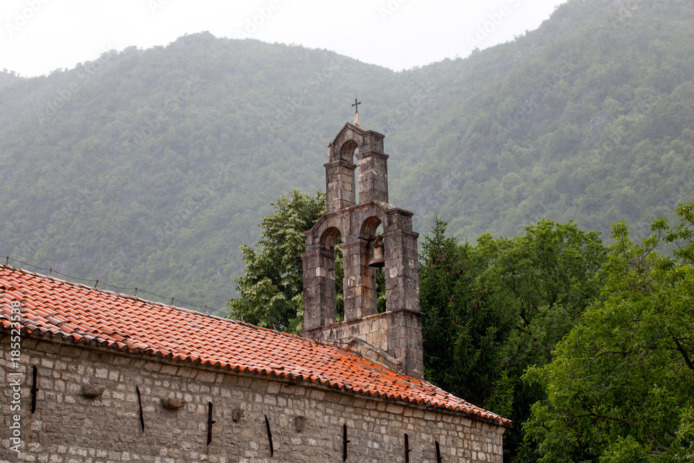Old monastery  with orange roof in front of mountains