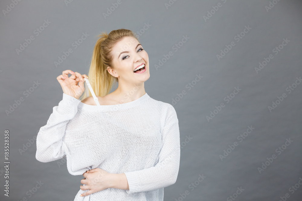 Happy woman holding her bra strap Happy woman holding her bra strap