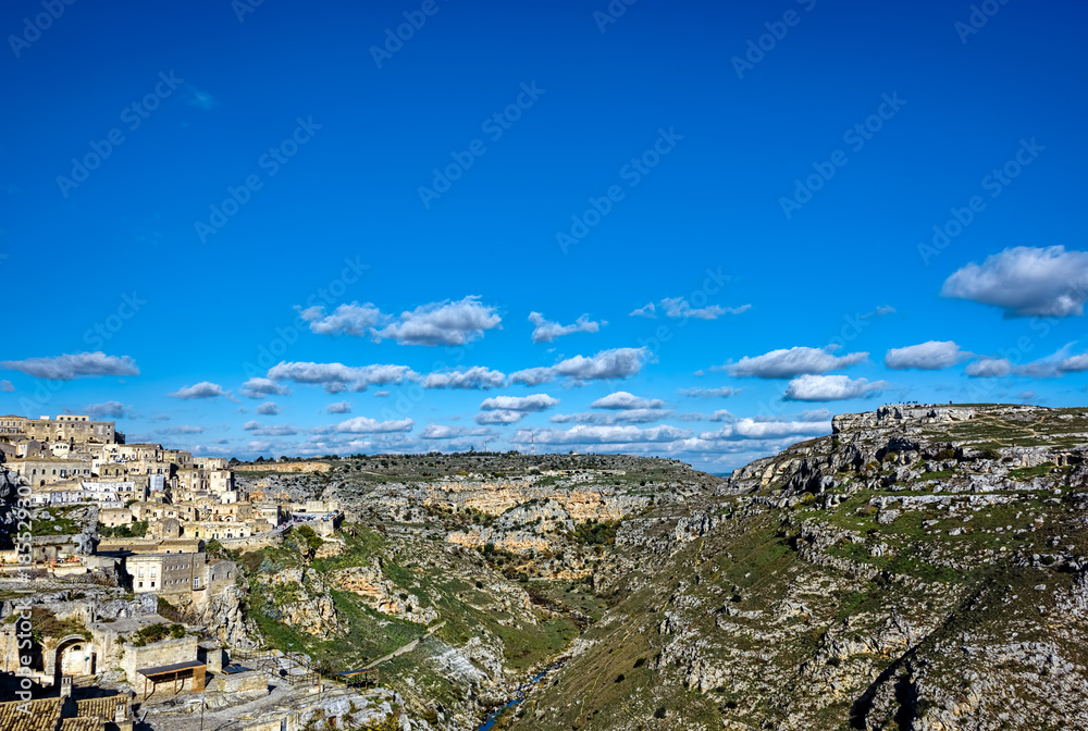 Naklejka premium A city on a rocky outcrop and a complex of cave dwellings carved