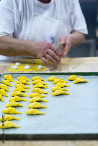 Making, preparing and stuffing tortellini con la coda pasta in Piacenza, Italy photo