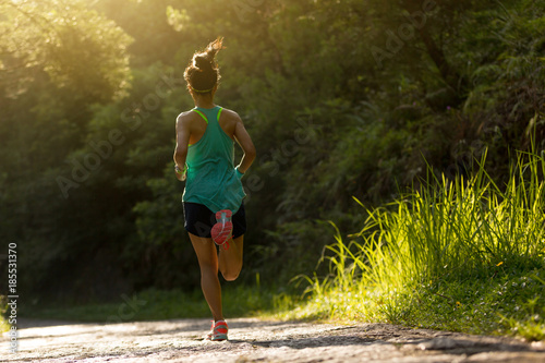 Fototapeta Naklejka Na Ścianę i Meble -  Young fitness woman athlete running on forest trail