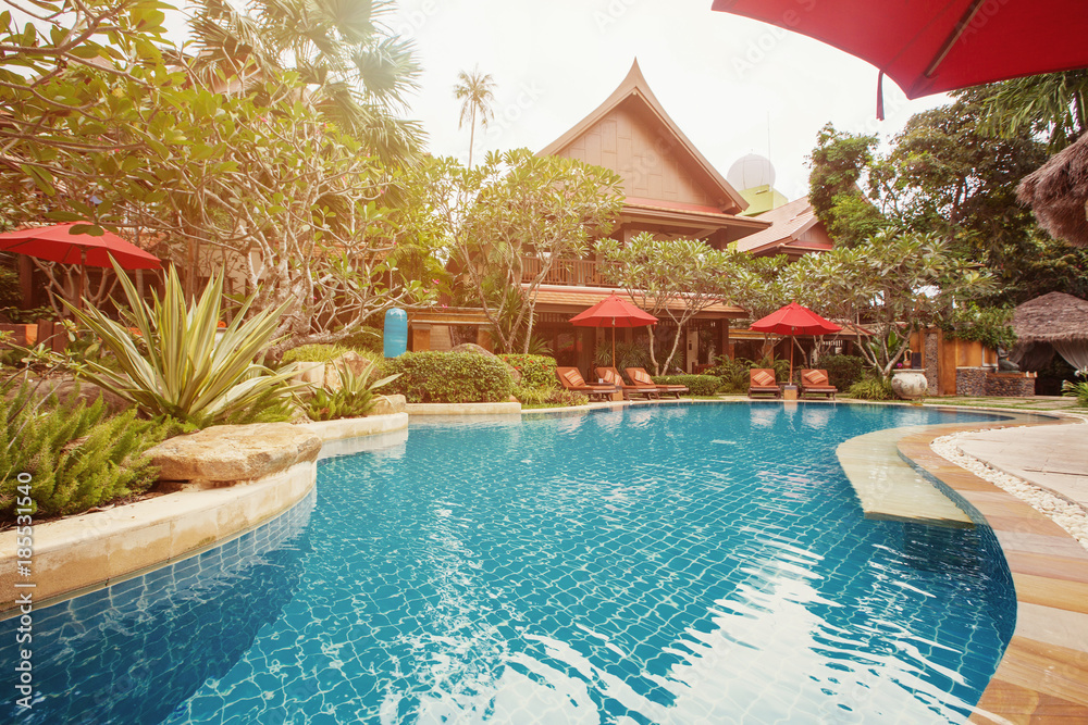 Swimming pool area in luxury hotel resort. Hot summer day, holiday and travel in asia