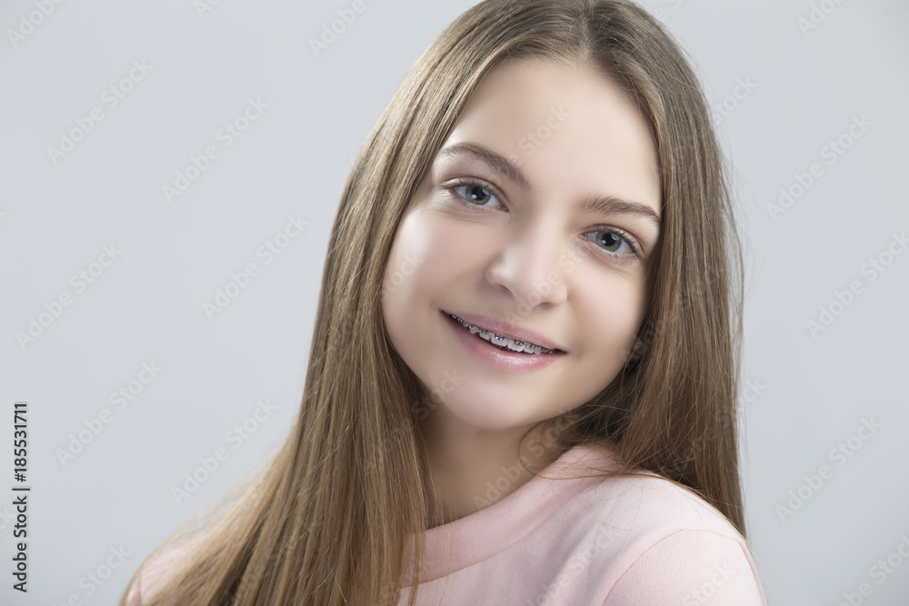 Dental and Oralcare Concepts.Portrait of Teenage Female Having Teeth Brackets. Posing with Smile Against White Dental and Oralcare Concepts.Portrait of Teenage Female Having Teeth Brackets. Posing with Smile Against White