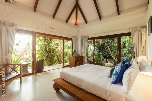 Modern bed room interior in Luxury villa. White colours, big window © Annatamila