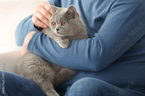 Senior man holding cute cat, closeup