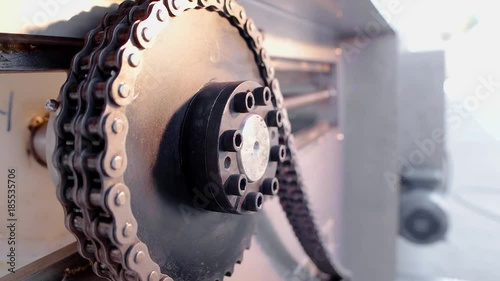 Metal pulley belt and gears with chain turning. Close up. Slow motion