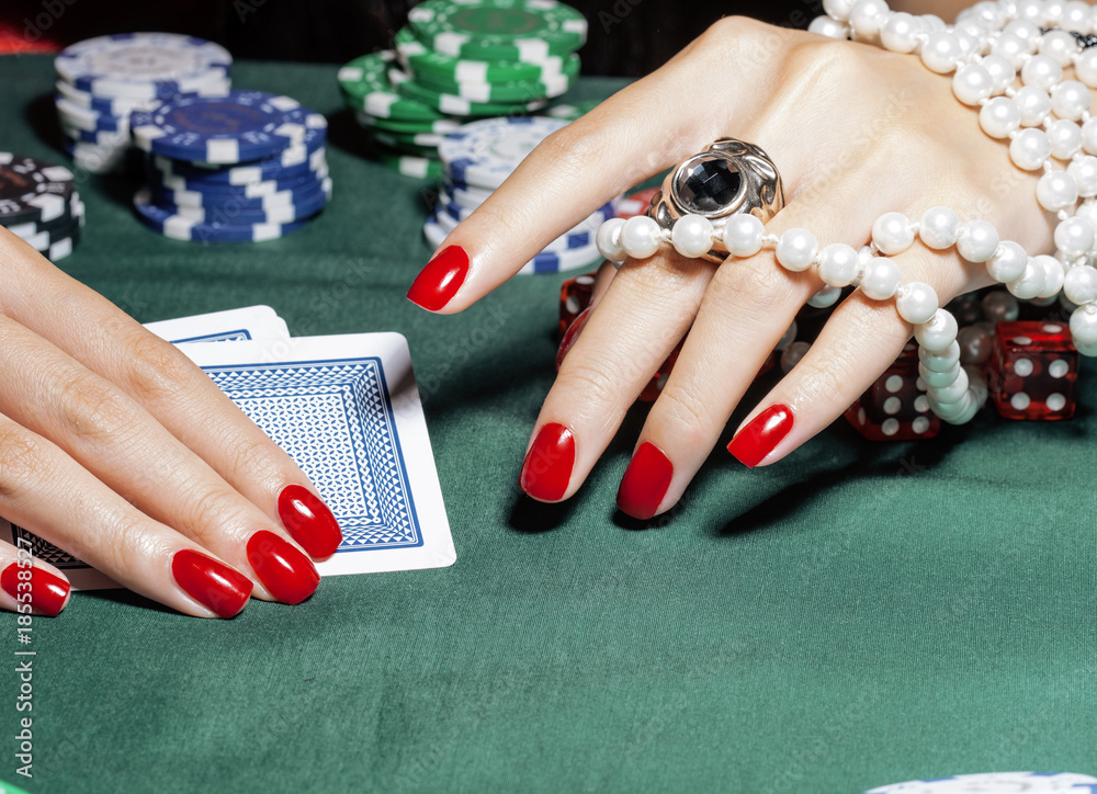 Φωτογραφία hands of young caucasian woman with red manicure at casino table close up