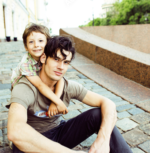 little son with father in city hagging and smiling, casual look photo