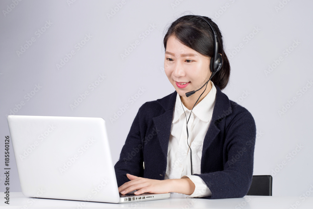 Young, confident and beautiful customer support operator with a computer Young, confident and beautiful customer support operator with a computer