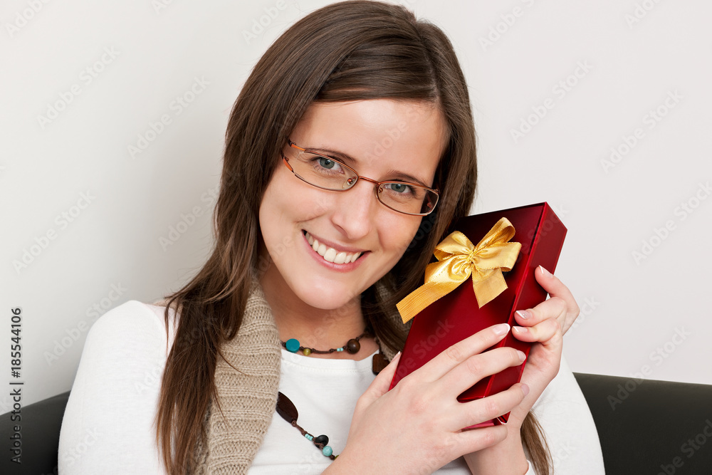 Attractive woman holding a gift box and smiling happily Attractive woman holding a gift box and smiling happily