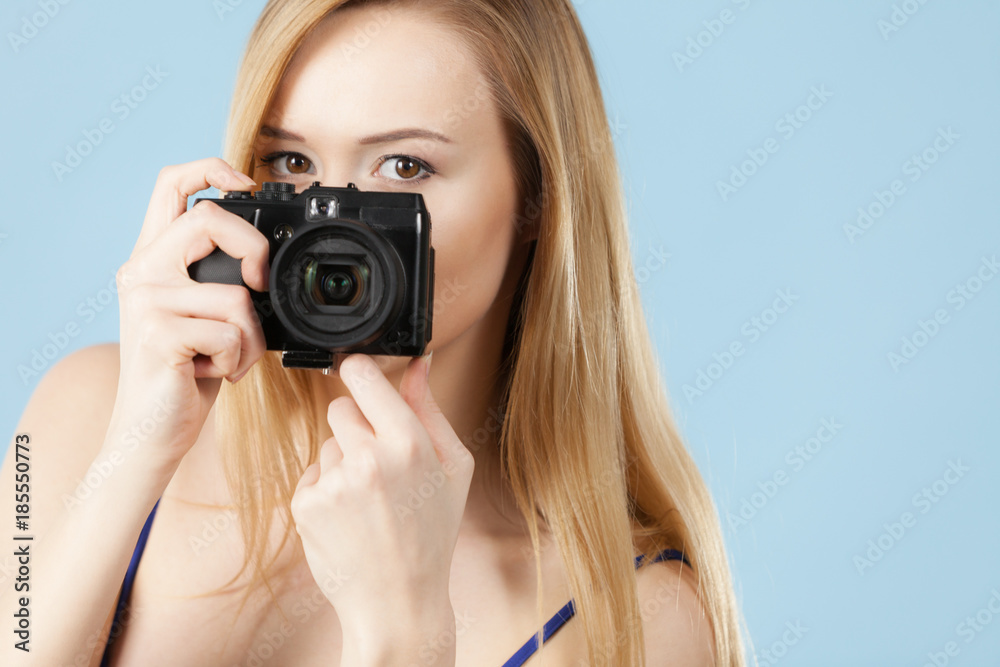 Blonde woman with camera on blue Blonde woman with camera on blue