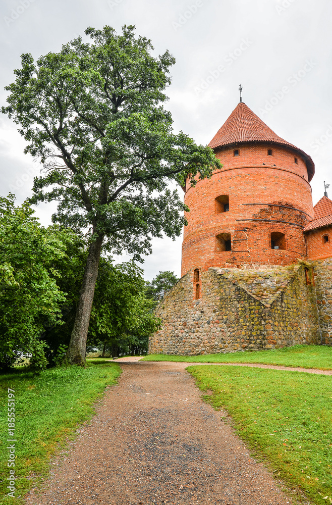 Trakai, Lithuania - August 15, 2017: Beautiful landscape of ancient Trakai Island Castle with road and tree, Lithuania. Trakai Island Castle and dramatic sky with clouds. 