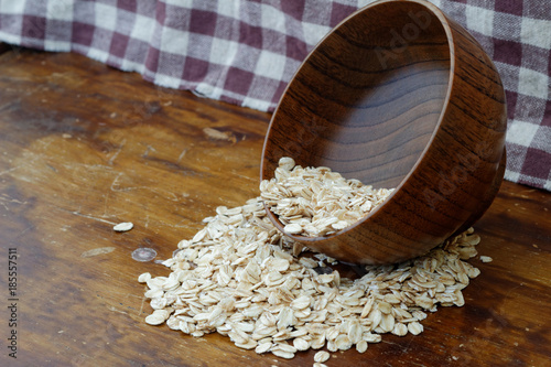 Oat spilling out from wooden bowl