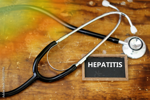 Word HEPATITIS written on mini blackboard with stethoscope on wooden table photo