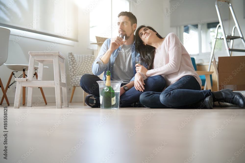 Couple cheering with champagne in new home
