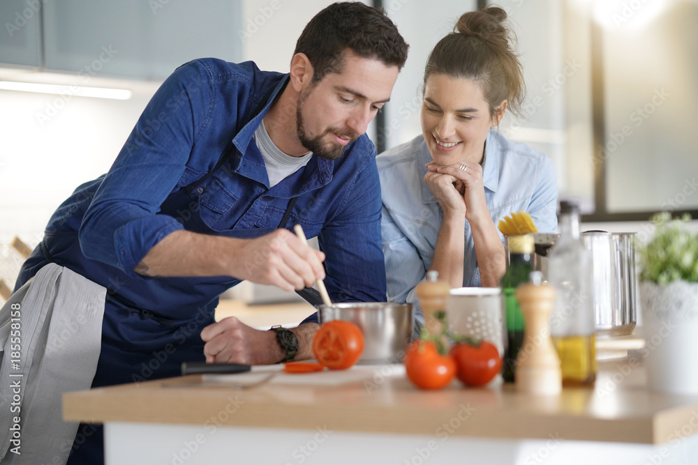 Couple at home having fun cooking together Couple at home having fun cooking together