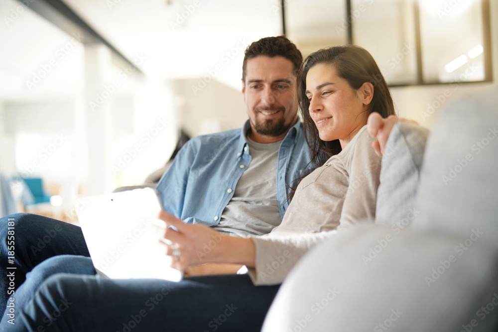 Couple relaxing in sofa and connected with digital tablet Couple relaxing in sofa and connected with digital tablet