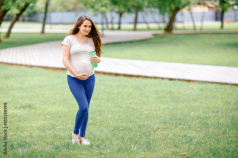 Beautiful pregnant girl walking in the Park. Beautiful pregnant girl walking in the Park.