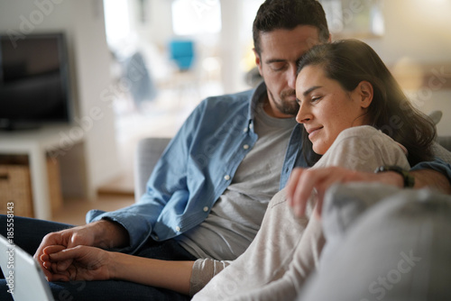 Couple relaxing in sofa and connected with digital tablet