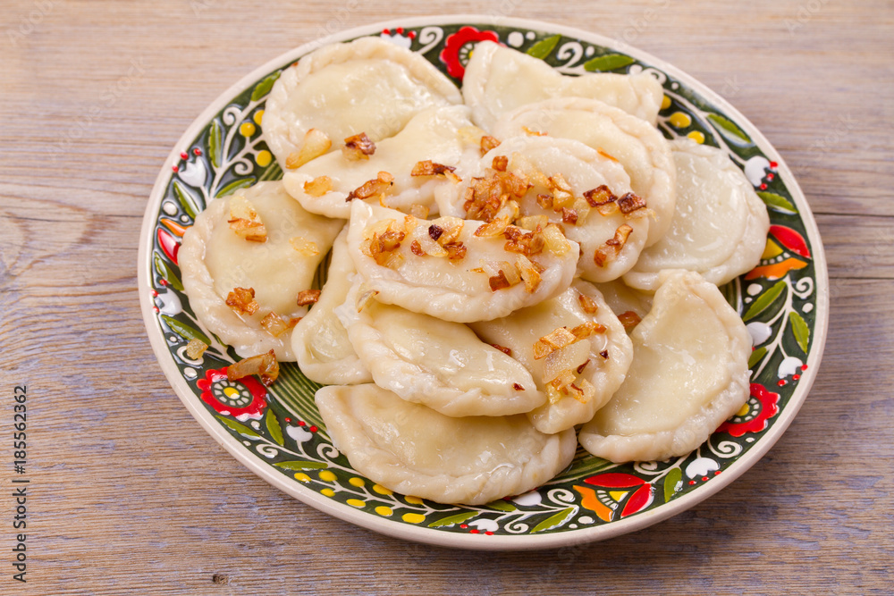 Dumplings, filled with potato and served with fried onion. Varenyky, vareniki, pierogi, pyrohy