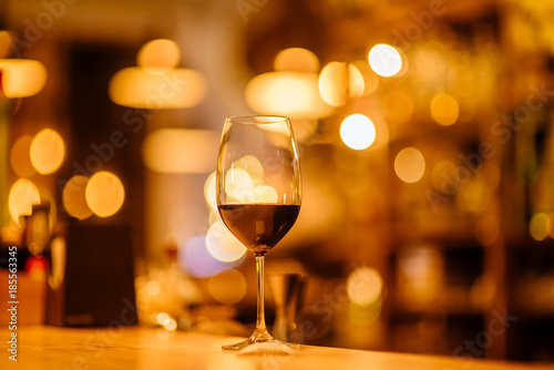 Red wine in evening lights in loft . Picture toned. Bokeh image