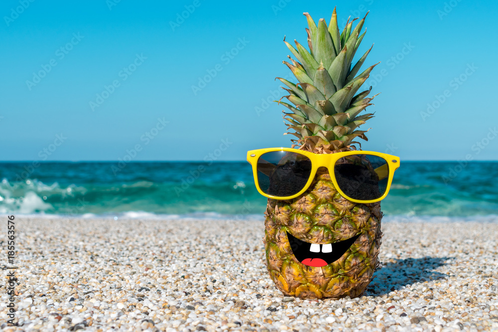 Funny pineapple in sunglasses on beach. Stock-foto |