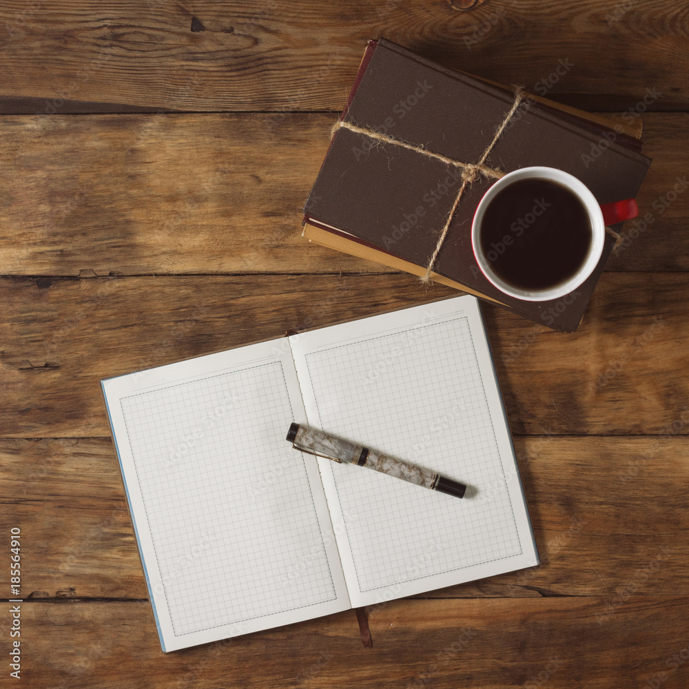 A stack of books, a diary, a pen and a cup of coffee A stack of books, a diary, a pen and a cup of coffee