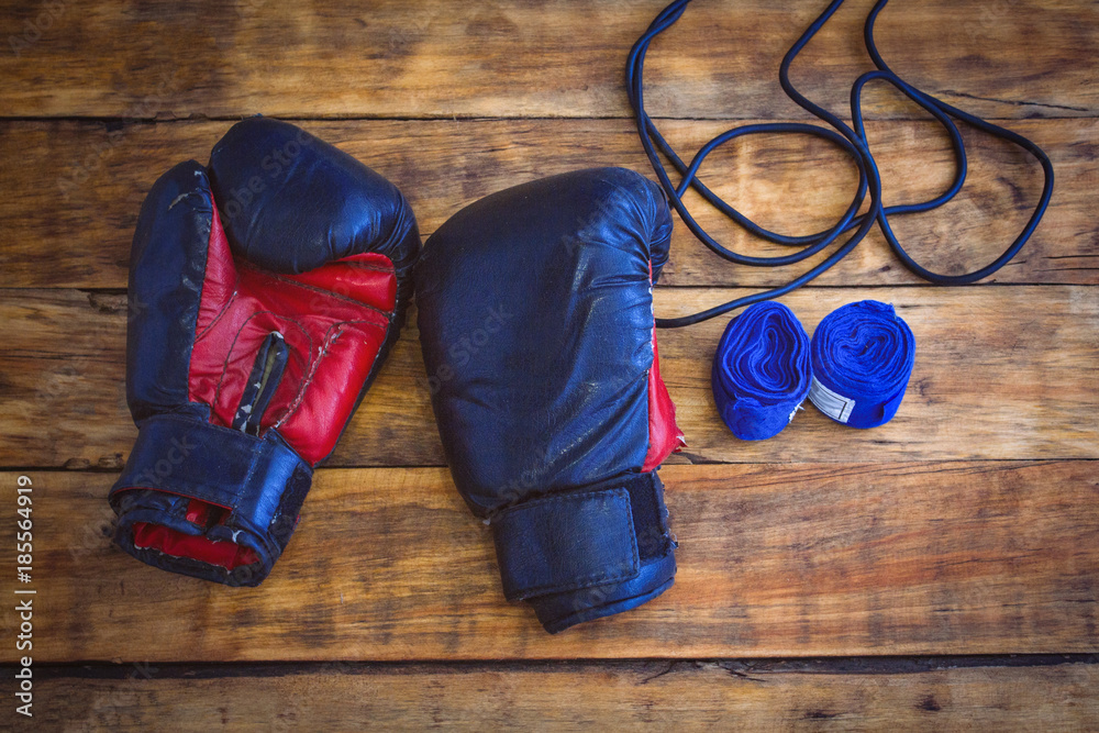 Boxing gloves, rope, taping bandages on a wooden table