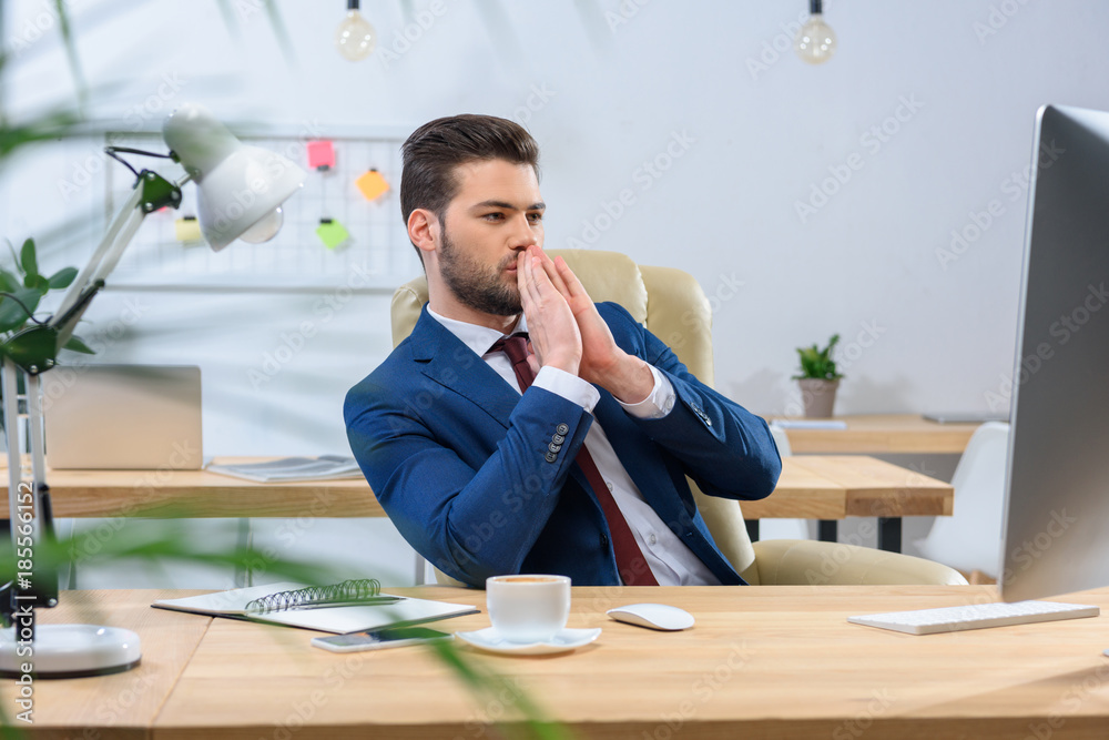 businessman looking at computer and showing hope gesture