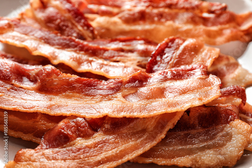 Cooked bacon rashers on plate, closeup