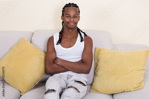Young African-American man sitting on couch photo