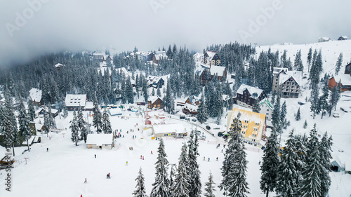 Snow-covered ski resort in the mountains with Christmas trees