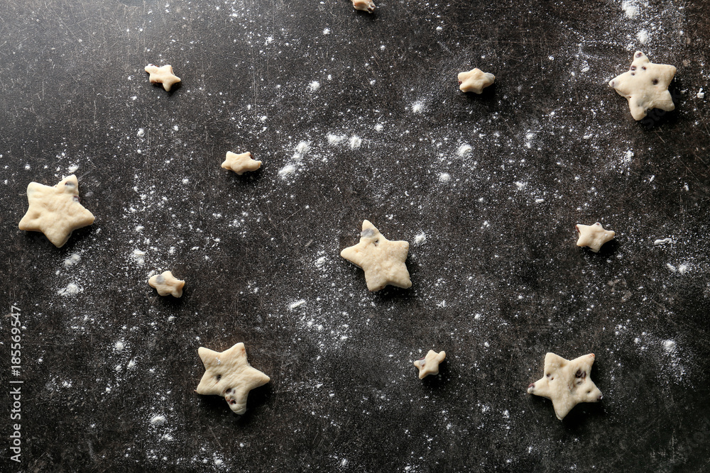 Fototapeta premium Raw cookies in shape of stars on dark background