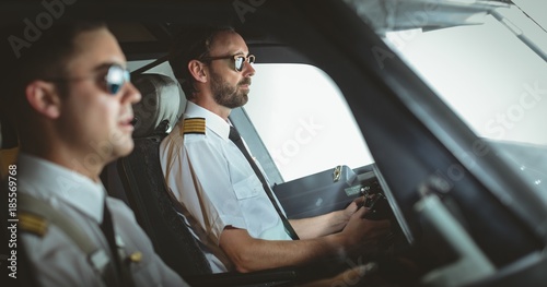 Pilot and copilot flying an airplane photo