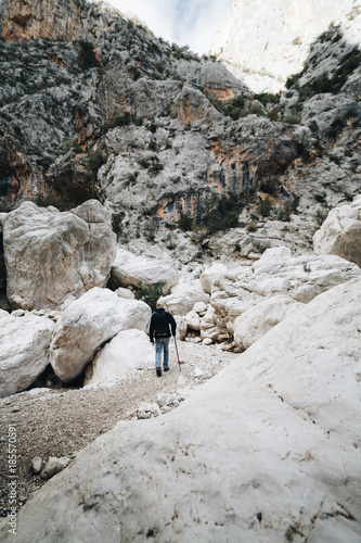 Aged Man hiking insdide the deepest canyon  in Europe - Activity and Health concept - Gola Su Gorroppu photo