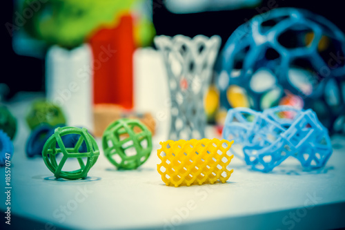 Many abstract models bright colorful objects printed on a 3d printer on a white table. Fused deposition modeling, FDM. Progressive modern additive technology. Concept of 4.0 industrial revolution