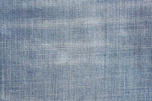 Worn blue jeans texture. Denim fabric background.