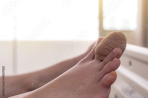 close up of bandage index toe of the female patient sleeping in the patient bed after an accident with sunbeam photo